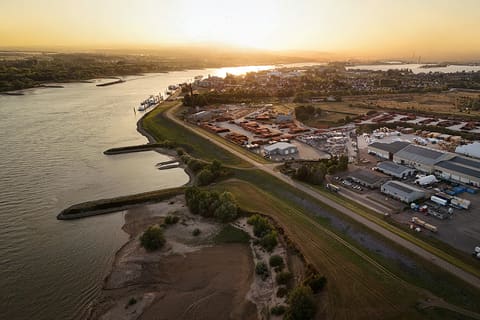 Vue aérienne au coucher du soleil d'une zone industrielle au bord du fleuve
